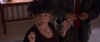 Movie still from “Bridget Jones's Diary” (2001), directed by Sharon Maguire – An older woman wearing a black hat and pearls; Close Up shot, Over the shoulder angle