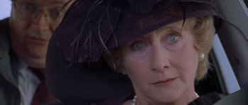 Movie still from “Bridget Jones's Diary” (2001), directed by Sharon Maguire – An older woman wearing a black hat and pearls; Close Up shot, Over the shoulder angle