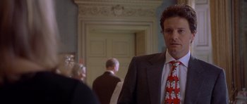 Movie still from “Bridget Jones's Diary” (2001), directed by Sharon Maguire – A man in a suit and tie standing in a room; Close Up shot, Over the shoulder angle