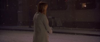 Movie still from “Bridget Jones's Diary” (2001), directed by Sharon Maguire – A woman standing on a sidewalk in the snow at night; Wide shot, Over the shoulder angle