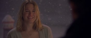 Movie still from “Bridget Jones's Diary” (2001), directed by Sharon Maguire – A woman smiles brightly while standing in front of a window; Close Up shot, Over the shoulder angle