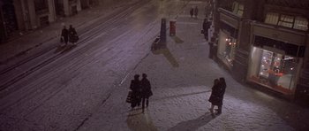 Movie still from “Bridget Jones's Diary” (2001), directed by Sharon Maguire – People are walking down a snowy sidewalk at night; Extreme Wide shot, High angle
