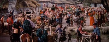 Movie still from “Brigadoon” (1954), directed by Vincente Minnelli – A crowd of people walking down a street; Wide shot, High angle