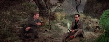 Movie still from “Brigadoon” (1954), directed by Vincente Minnelli – Two men sitting next to each other on the ground; Medium shot, High angle