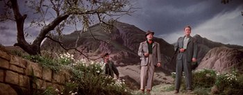 Movie still from “Brigadoon” (1954), directed by Vincente Minnelli – A man and a boy standing in a field; Wide shot, Low angle