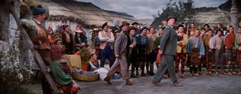 Movie still from “Brigadoon” (1954), directed by Vincente Minnelli – A group of people standing in front of a crowd; Wide shot, High angle