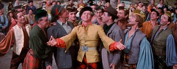 Movie still from “Brigadoon” (1954), directed by Vincente Minnelli – A group of men standing next to each other in a crowd; Medium shot, Low angle