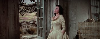 Movie still from “Brigadoon” (1954), directed by Vincente Minnelli – A woman in a dress standing in front of a window; Medium shot, Low angle