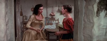Movie still from “Brigadoon” (1954), directed by Vincente Minnelli – Two women are talking to each other in a room; Medium shot, Over the shoulder angle