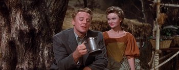 Movie still from “Brigadoon” (1954), directed by Vincente Minnelli – A man and a woman sitting next to each other; Medium shot, Low angle