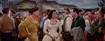 Movie still from “Brigadoon” (1954), directed by Vincente Minnelli – A group of men and women standing next to each other; Medium shot, Over the shoulder angle