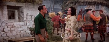 Movie still from “Brigadoon” (1954), directed by Vincente Minnelli – A man and a woman talking to each other in front of a crowd; Medium shot, Over the shoulder angle