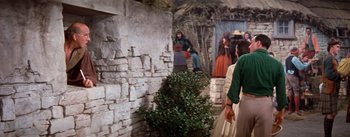 Movie still from “Brigadoon” (1954), directed by Vincente Minnelli – A group of people standing next to a brick wall; Medium shot, Low angle