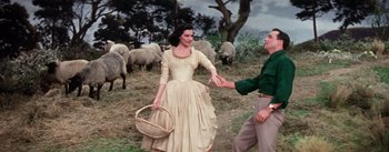 Movie still from “Brigadoon” (1954), directed by Vincente Minnelli – A woman and a man in a field with sheep in the background; Medium shot, Low angle