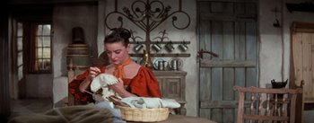 Movie still from “Brigadoon” (1954), directed by Vincente Minnelli – A woman sitting at a table with a basket of food; Medium shot, Over the shoulder angle