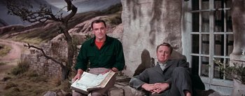 Movie still from “Brigadoon” (1954), directed by Vincente Minnelli – Two men sitting next to each other in front of a tree; Medium shot, Low angle