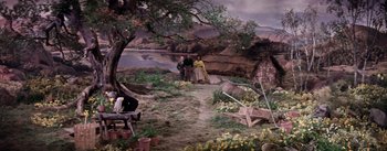 Movie still from “Brigadoon” (1954), directed by Vincente Minnelli – Two people standing on a dirt path next to a river; Extreme Wide shot, High angle