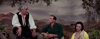 Movie still from “Brigadoon” (1954), directed by Vincente Minnelli – A man sitting on top of a tree next to another man; Medium shot, Low angle