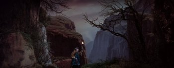 Movie still from “Brigadoon” (1954), directed by Vincente Minnelli – A man in a kilt standing in front of a mountain; Wide shot, Low angle