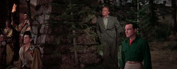 Movie still from “Brigadoon” (1954), directed by Vincente Minnelli – A man standing next to a tree in the woods; Medium shot, Low angle
