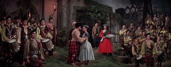 Movie still from “Brigadoon” (1954), directed by Vincente Minnelli – A man and a woman in medieval garb standing next to each other; Wide shot, Low angle