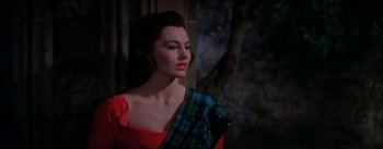 Movie still from “Brigadoon” (1954), directed by Vincente Minnelli – A woman in a red dress with a plaid scarf; Medium shot, Low angle