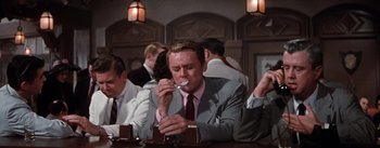 Movie still from “Brigadoon” (1954), directed by Vincente Minnelli – A man in a suit and tie eating a dessert; Medium shot, Low angle