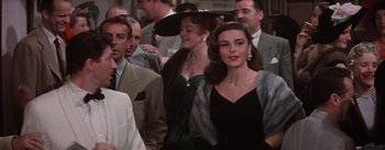 Movie still from “Brigadoon” (1954), directed by Vincente Minnelli – A group of people walking in a crowd of men and women; Medium shot, Over the shoulder angle