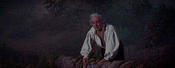 Movie still from “Brigadoon” (1954), directed by Vincente Minnelli – An older man in a white shirt and black pants; Medium shot, Low angle