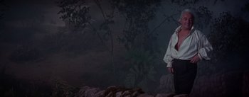 Movie still from “Brigadoon” (1954), directed by Vincente Minnelli – A man standing in front of a forest at night; Medium shot, Low angle
