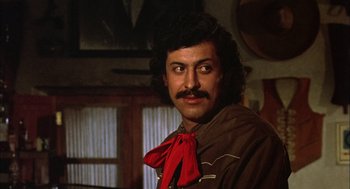 Movie still from “Bring Me the Head of Alfredo Garcia” (1974), directed by Sam Peckinpah – A person with a mustache wearing a red bow tie; Close Up shot, Low angle