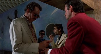 Movie still from “Bring Me the Head of Alfredo Garcia” (1974), directed by Sam Peckinpah – A group of men standing next to each other in a room; Medium shot, Low angle