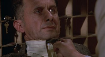 Movie still from “Bring Me the Head of Alfredo Garcia” (1974), directed by Sam Peckinpah – A man adjusting a tie of a neck tie; Close Up shot, Low angle