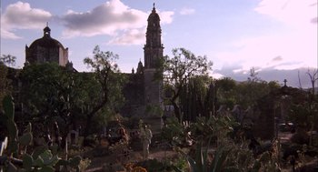 Movie still from “Bring Me the Head of Alfredo Garcia” (1974), directed by Sam Peckinpah – People are standing in a field near a tall tower; Extreme Wide shot, Low angle
