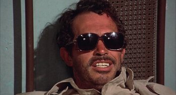 Movie still from “Bring Me the Head of Alfredo Garcia” (1974), directed by Sam Peckinpah – A person wearing sunglasses; Close Up shot, High angle
