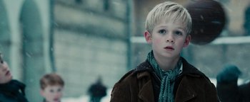 Movie still from “The Book Thief” (2013), directed by Brian Percival – A young boy with blonde hair wearing a brown jacket and a green scarf; Close Up shot, Low angle