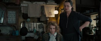 Movie still from “The Book Thief” (2013), directed by Brian Percival – A woman standing next to another woman in a room; Medium shot, Over the shoulder angle