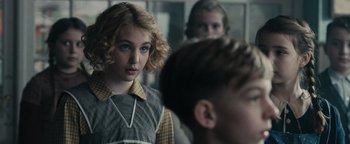 Movie still from “The Book Thief” (2013), directed by Brian Percival – A young girl looking at the camera while a younger boy looks on; Close Up shot, Over the shoulder angle