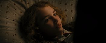 Movie still from “The Book Thief” (2013), directed by Brian Percival – A young girl is laying down and looking at the camera; Close Up shot, High angle