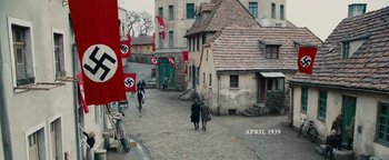 Movie still from “The Book Thief” (2013), directed by Brian Percival – Two people are riding horses down a street; Extreme Wide shot, High angle