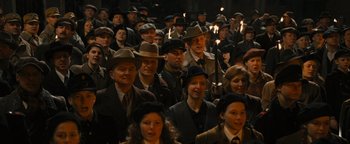 Movie still from “The Book Thief” (2013), directed by Brian Percival – A group of people wearing hats and standing in a room; Wide shot, High angle