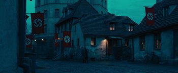 Movie still from “The Book Thief” (2013), directed by Brian Percival – Two men are standing in front of a building; Extreme Wide shot, Low angle