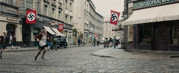 Movie still from “The Book Thief” (2013), directed by Brian Percival – People walking down a street with a nazi flag on the ground; Extreme Wide shot, High angle