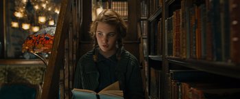 Movie still from “The Book Thief” (2013), directed by Brian Percival – A young girl is reading a book in a library; Close Up shot, High angle
