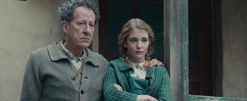 Movie still from “The Book Thief” (2013), directed by Brian Percival – A man standing next to a young girl in front of a building; Close Up shot, Over the shoulder angle