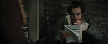 Movie still from “The Book Thief” (2013), directed by Brian Percival – A man is reading a newspaper while sitting on a ledge; Close Up shot, High angle