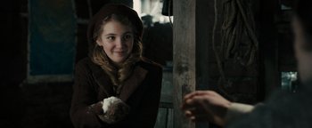 Movie still from “The Book Thief” (2013), directed by Brian Percival – A young woman holding a piece of cake in her hands; Close Up shot, Over the shoulder angle