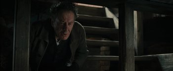 Movie still from “The Book Thief” (2013), directed by Brian Percival – An older man leaning on a wooden stair case; Medium shot, Low angle