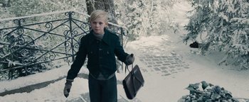 Movie still from “The Book Thief” (2013), directed by Brian Percival – A young boy holding a briefcase in the snow; Medium shot, High angle