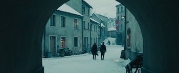 Movie still from “The Book Thief” (2013), directed by Brian Percival – Two people walking down a snow covered street; Wide shot, Over the shoulder angle